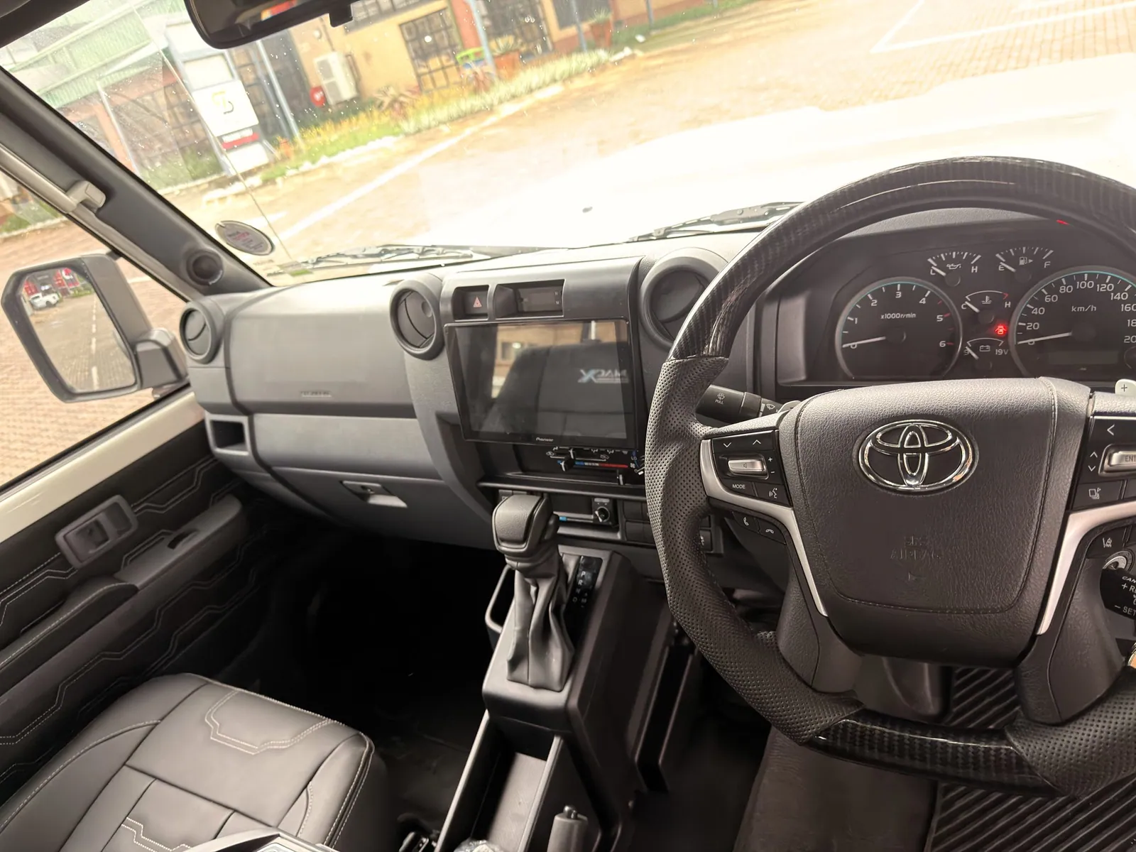 Dashboard with touchscreen head unit and leather trim — King Cruiser — JMACX Coil-Converted Land Cruiser 79, fitted by Venture 4x4 in Nelspruit