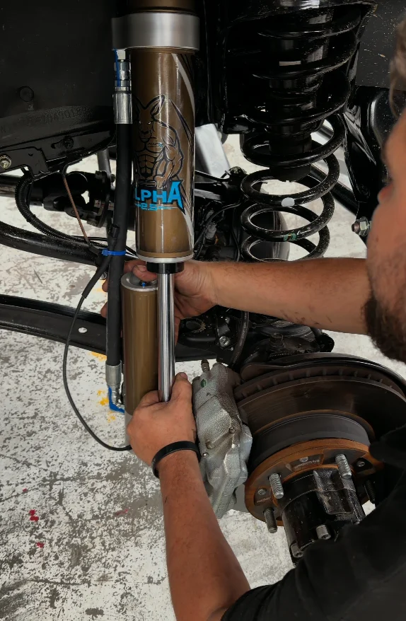 Technician installing suspension components in the Venture 4x4 workshop